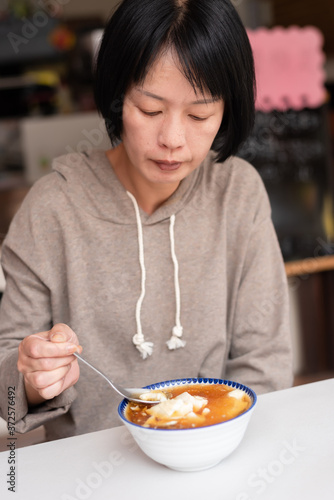 Asian woman eat tofu pudding