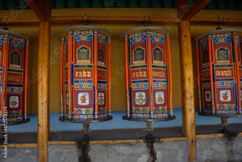 Tibetan prayer wheels at Labrang Monastery in Xiahe County, China. Translation text written in sanskrit means "jewel in the lotus"