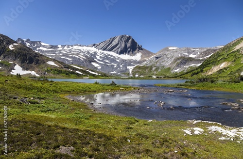 Blue Aster Lake, Scenic Alpine Meadow and Warrior Rocky Mountain Peak Landscape on a hiking trail in Kananaskis Country, Alberta, Canada on a sunny summertime day 