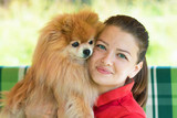 portrait of happy young woman with spitz. beautiful girl huging a Pomeranian. Love and friendship between animal and owner. Pet adoption. human and dog together