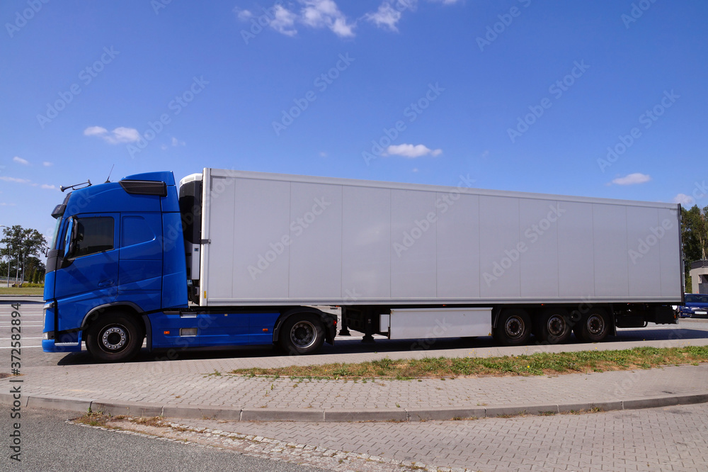 A blue truck with a white trailer. Break in a trip. A blue truck with a white trailer. Break in a trip.