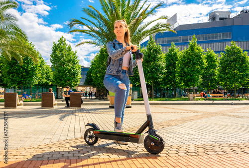 City scooter. Kick electric bike using from business woman. Public mobile transportation in European city center.