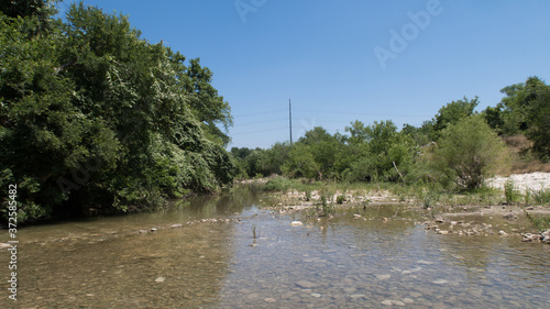 a shallow creek bed wotj smooth rocks clearly visible photo