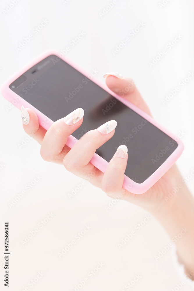 スマートフォンを持つ女性の手元