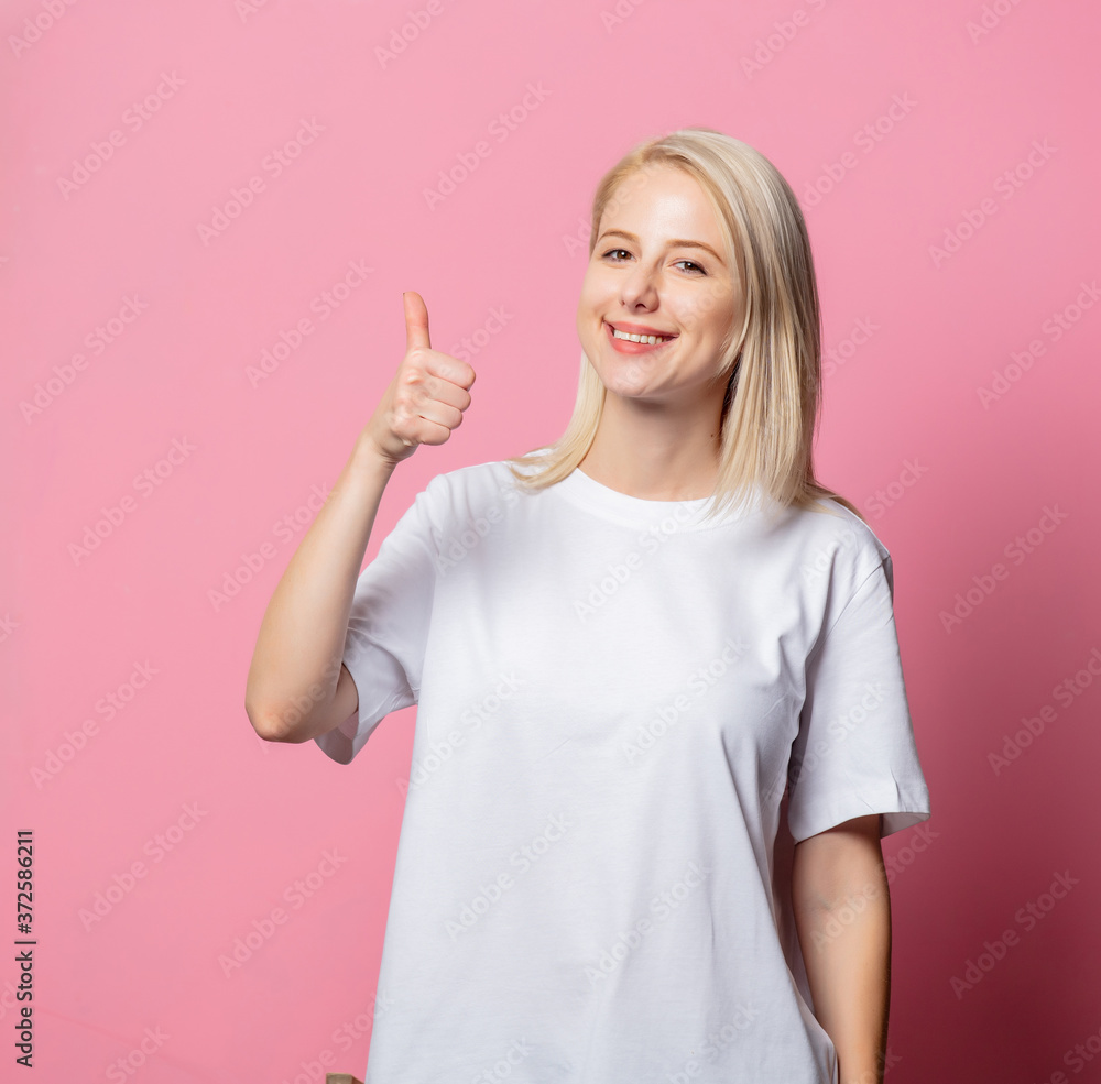 Blonde woman in white moch-up tshirt on pink background Blonde woman in white moch-up tshirt on pink background