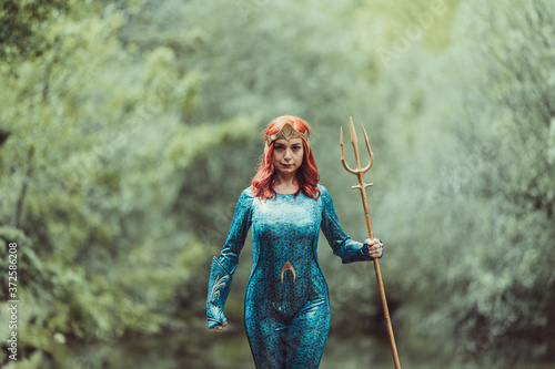 Redhead woman posing with superhero costume