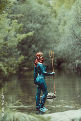 Redhead woman posing with superhero costume