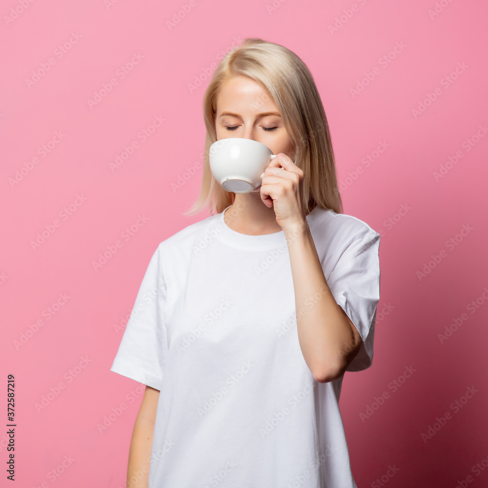 Blonde woman in white moch-up tshirt with cup of coffee Blonde woman in white moch-up tshirt with cup of coffee