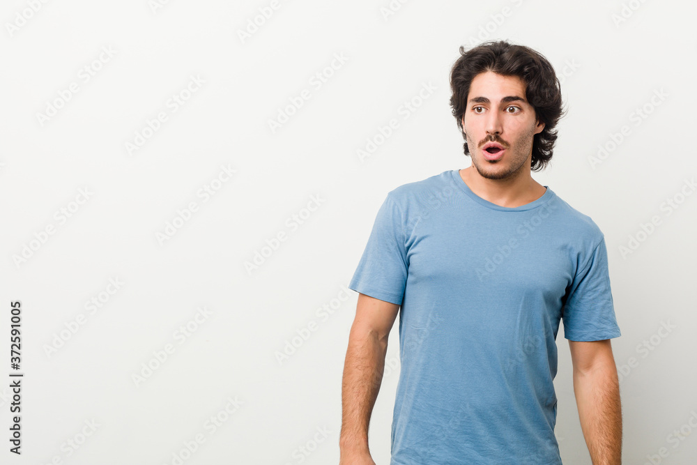 Young handsome man against a white background being shocked because of something she has seen. Young handsome man against a white background being shocked because of something she has seen.