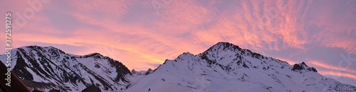 Photography colorful dusk with light clouds and snowy mountains in the foreground