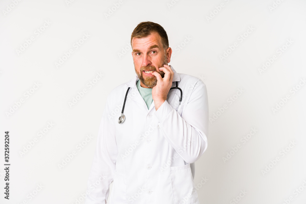 Senior doctor man isolated on white background biting fingernails, nervous and very anxious.