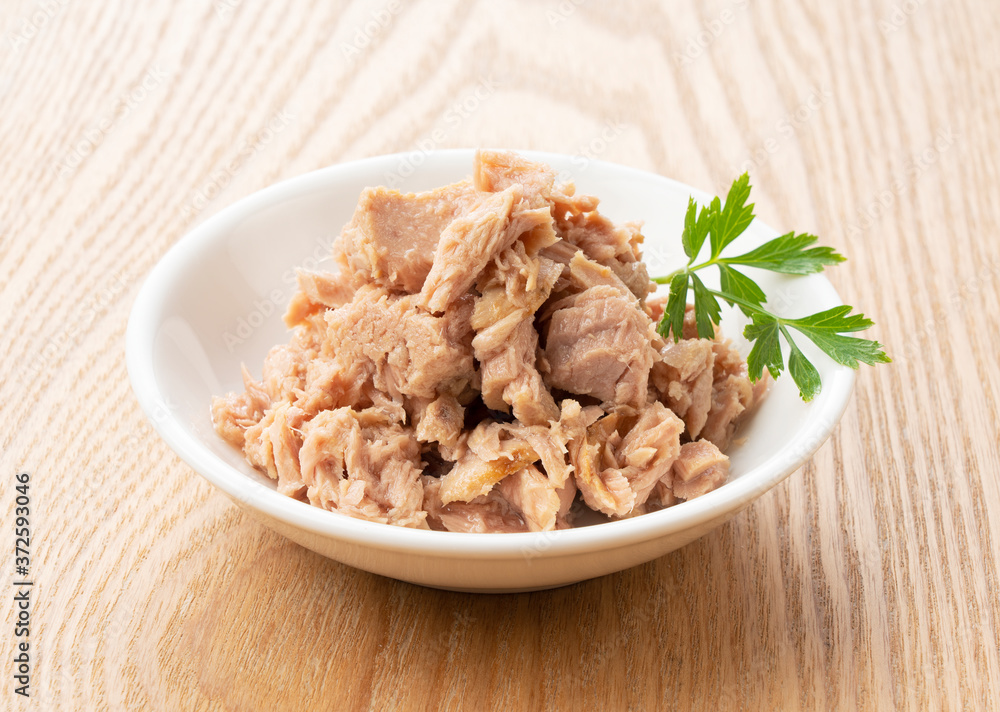 Tuna and Italian parsley on a wooden background Tuna and Italian parsley on a wooden background
