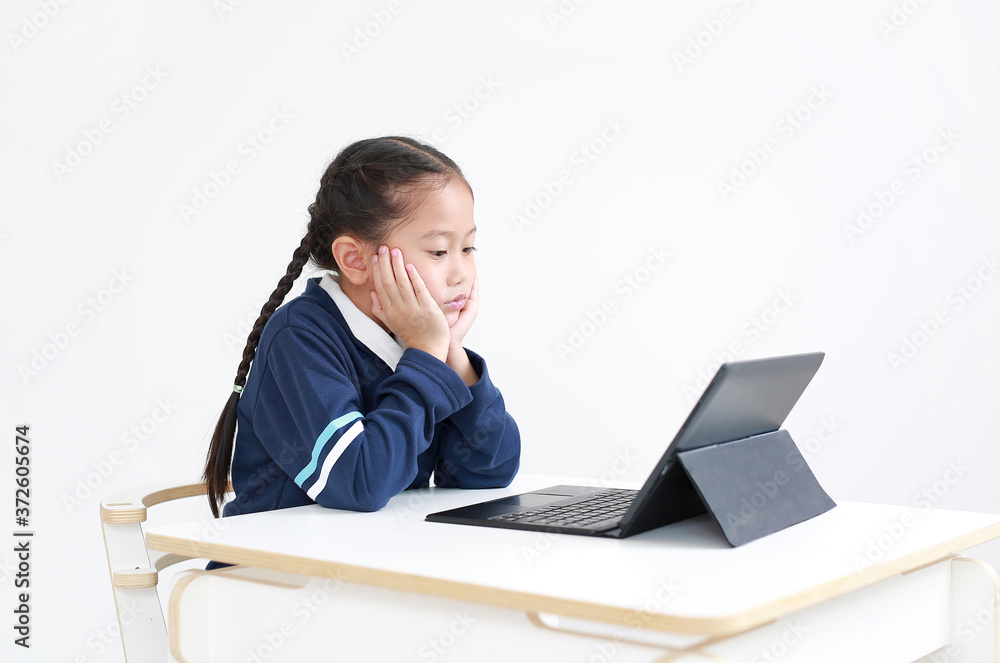 Portrait asian little child girl in school uniform using laptop on table isolated on white background, Studio shot Portrait asian little child girl in school uniform using laptop on table isolated on white background, Studio shot