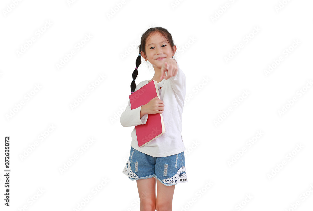 Cheerful smiling asian little girl hold book isolated on white background. Kid embracing a notebook and pointing at camera. Cheerful smiling asian little girl hold book isolated on white background. Kid embracing a notebook and pointing at camera.