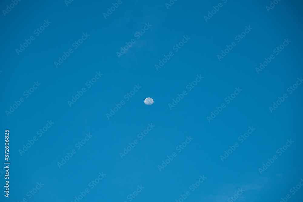 Irregular white cloud on blue sky with small the Moon in the daytime Irregular white cloud on blue sky with small the Moon in the daytime