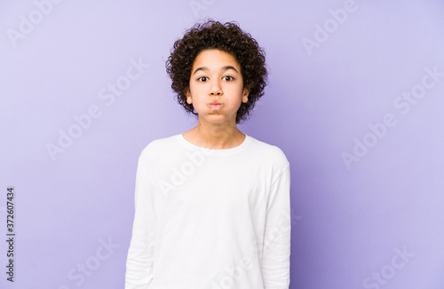 African american little boy isolated blows cheeks, has tired expression. Facial expression concept.