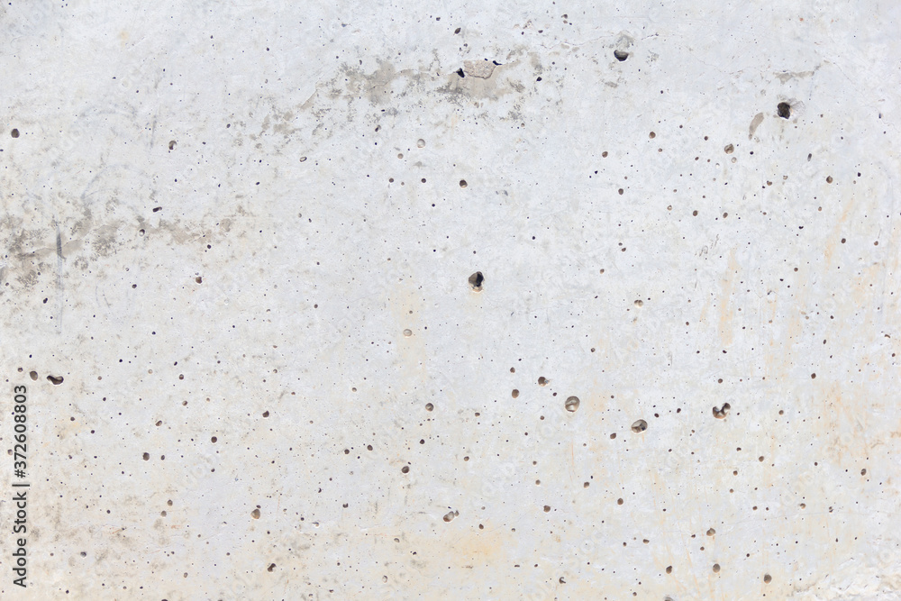 Texture of an aged and weathered grey concrete exterior wall. Plenty of holes around the surface. Conctruction and materials Texture of an aged and weathered grey concrete exterior wall. Plenty of holes around the surface. Conctruction and materials