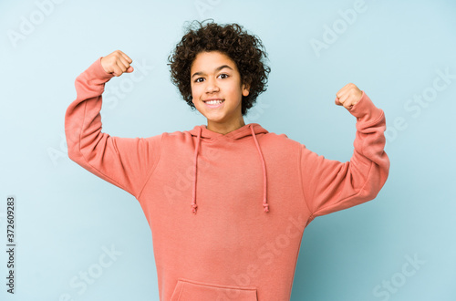 Quadro su tela African american little boy isolated showing strength gesture with arms, symbol