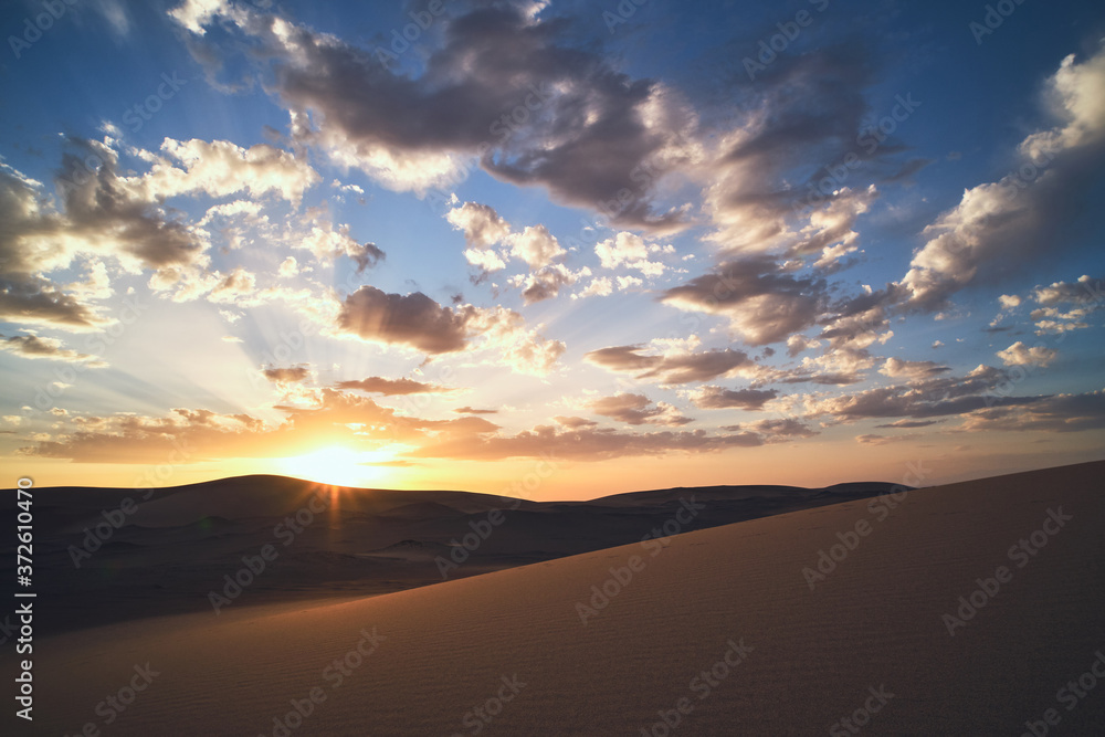 Minimalistic desert landscape with sandy dunes and beautiful sunset with blue sky in Hami, Xinjiang in China Minimalistic desert landscape with sandy dunes and beautiful sunset with blue sky in Hami, Xinjiang in China