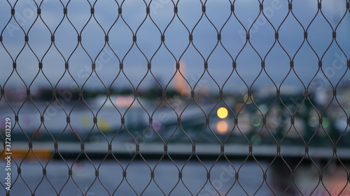Wire mesh grating in the city background