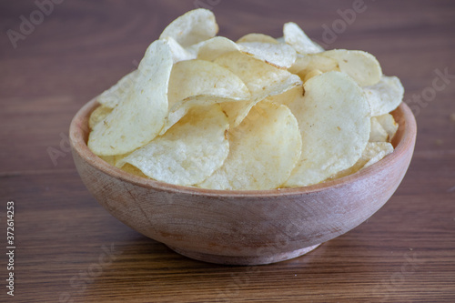 Homemade Potato Chips in bowl on wooden table