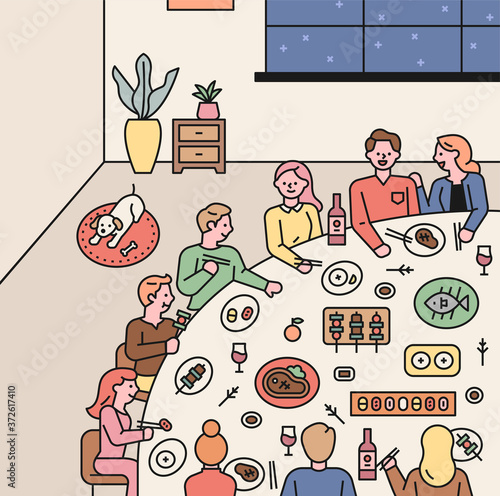 People are having a party around a large dining table. Landscape inside the house.