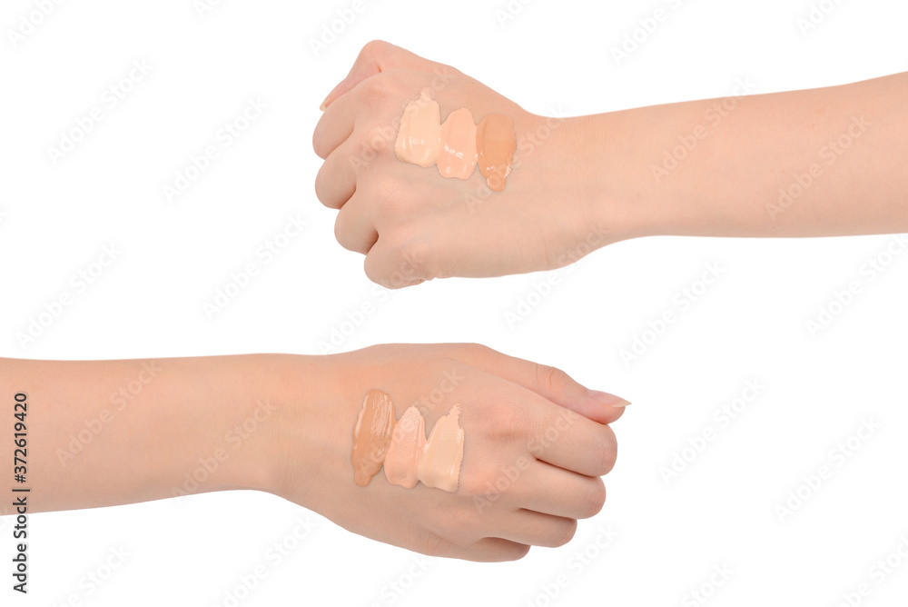 Fair, medium, dark swatches  of foundation on the hand isolated on white.