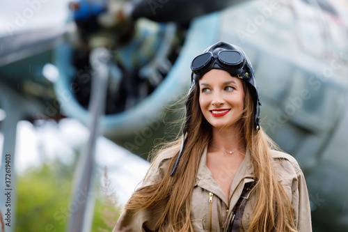 Portrait of a young attractive woman pilot in a helmet and pilot suit