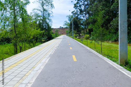 One way street view with grass and trees around and bike path