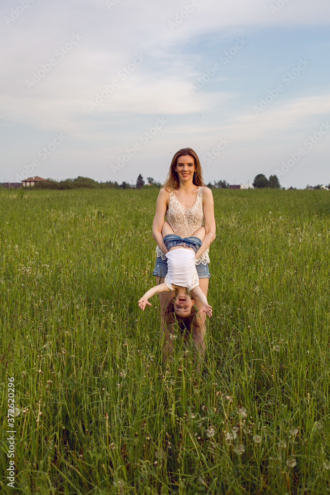 mom and daughter in white t-shirts and denim shorts have fun