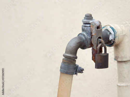 Rusted faucet locked with old bolt. With space for place your text.