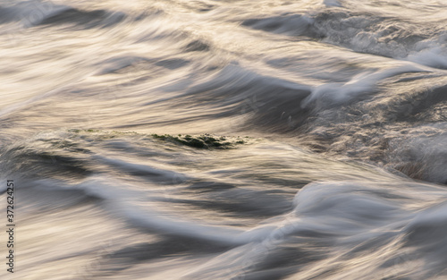 Soft Focus And Blurred Image Wave Hitting The Rock At The Beach at sunrise