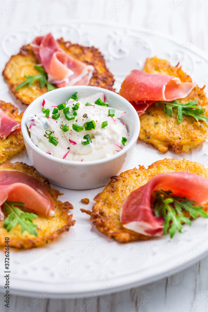 Potato pancake with prosciutto and dip of radishes cream cheese and chives