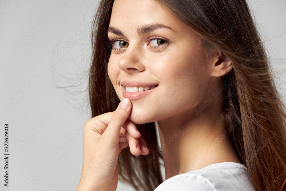 Smiling woman holds her hand near her mouth close-up Smiling woman holds her hand near her mouth close-up