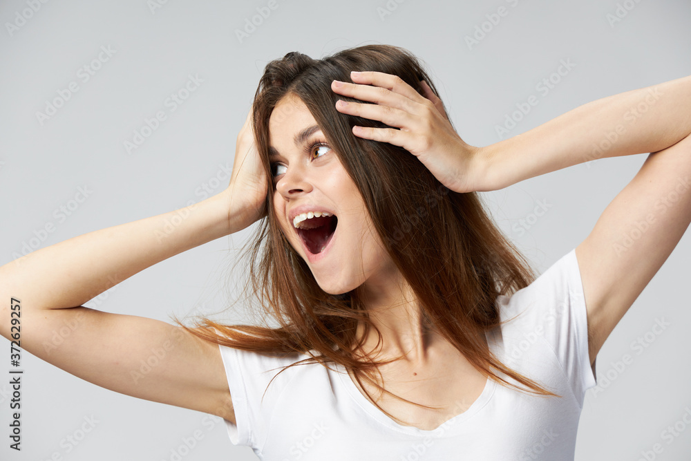 Woman with open mouth holds her head look to the side white t-shirt emotions Woman with open mouth holds her head look to the side white t-shirt emotions