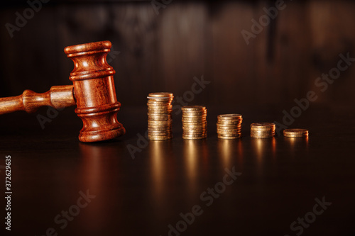TAX payment concept. Stack of coins with wooden judge gavel