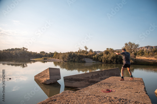 man training next to river © robcartorres