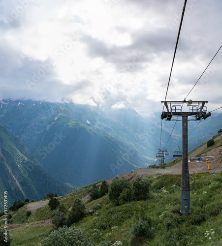 Aerial aerial cableway support in Dombay against dramatic sky in summer, beautiful mountains landscape, Caucasus, Russia