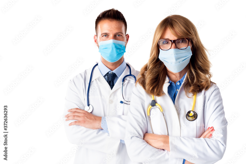 Shot of male and female doctors wearing face mask while standing together at isolated white background Shot of male and female doctors wearing face mask while standing together at isolated white background