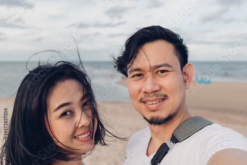 Funny wow face selfie of couple on windy beach. © Sevendeman