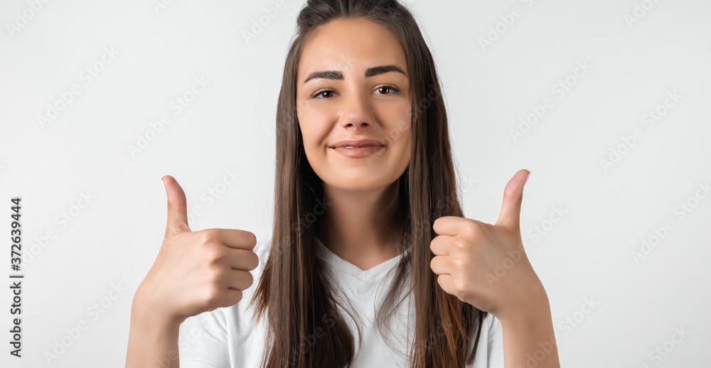 Good job. Pretty carefree modern stylish European girl with long chestnut hair making OK with both hands, gesture as if saying that everything is finee, white background Good job. Pretty carefree modern stylish European girl with long chestnut hair making OK with both hands, gesture as if saying that everything is finee, white background