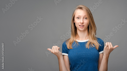 Wallpaper Mural Beautiful young female with blonde straight hair looking is surprise at the camera, holding two thumbs down. Human emotions, facial expression concept. Torontodigital.ca