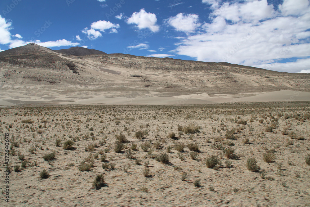 View of the mountain and sand dune with dirt road in a sunny day, Tibet, China