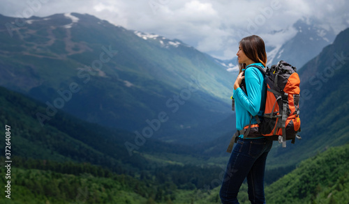 Backpacker on top of a mountain enjoying valley view