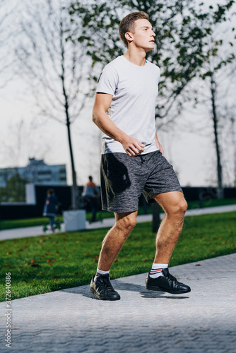 A man in shorts goes in for sports in a park in nature and a model running sneakers
