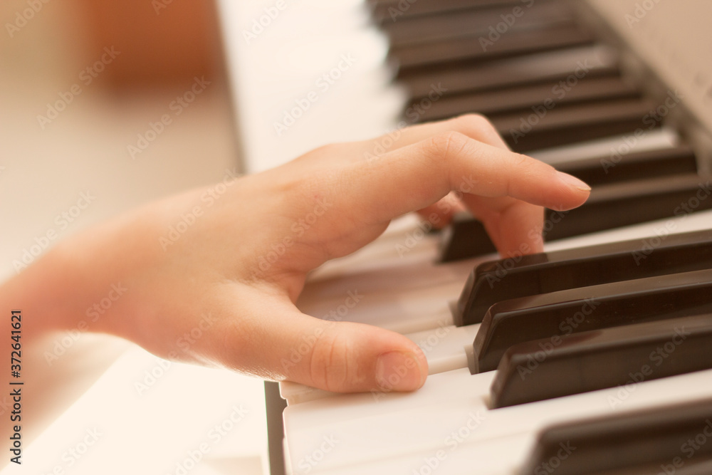 Obraz premium Children's hands play the piano. Close-up. The background