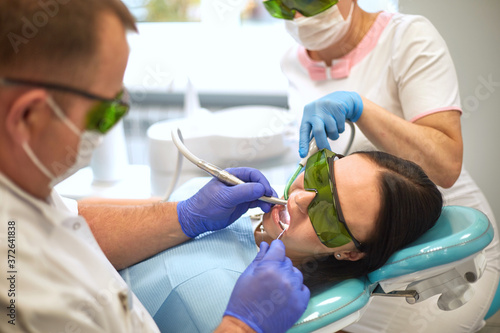 Doctor dentist treats teeth of a beautiful young girl patient. The girl on reception at the dentist. Doctor dentist treats tooth