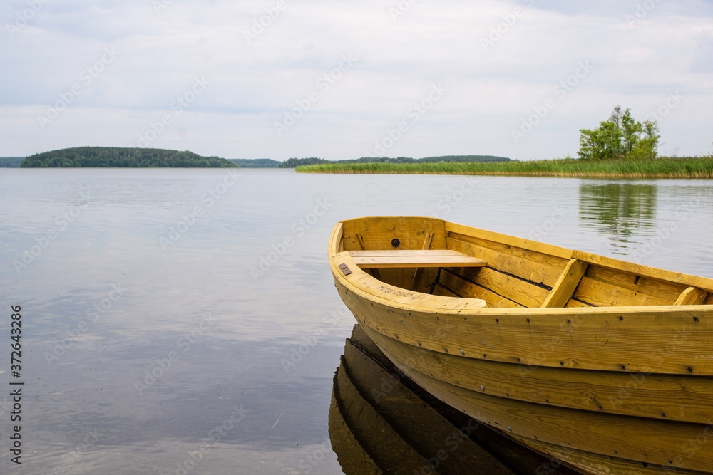 Boat on the lake. Wooden boat on a calm summer lake or river in summer. Zen nature background. Boat on the lake. Wooden boat on a calm summer lake or river in summer. Zen nature background.
