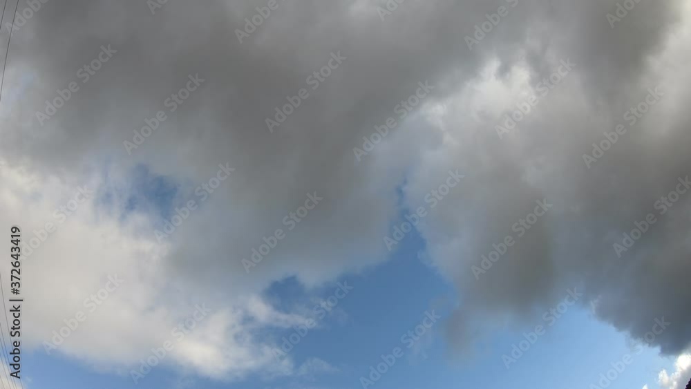 Clouds dark and grey moving across the sky with patches of blue skies coming through Clouds dark and grey moving across the sky with patches of blue skies coming through