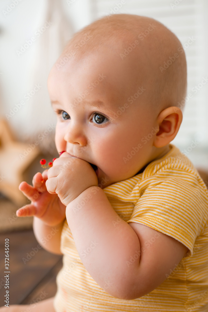 Cute toddler eats fruit in wooden kitchen at home Cute toddler eats fruit in wooden kitchen at home